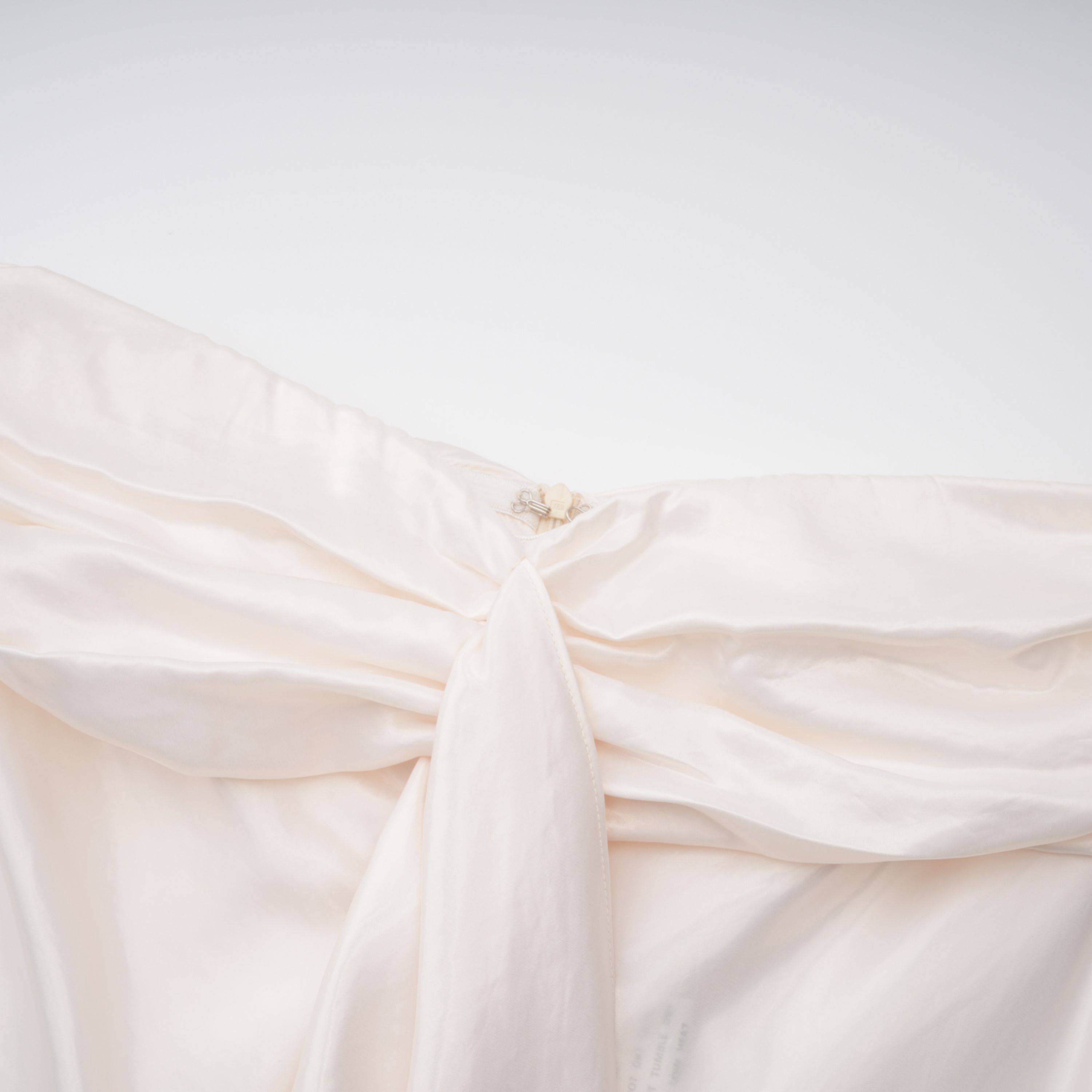 فستان طويل من الساتان باللون البيج الفاتح بدون أكمام ومزين بكشكشة