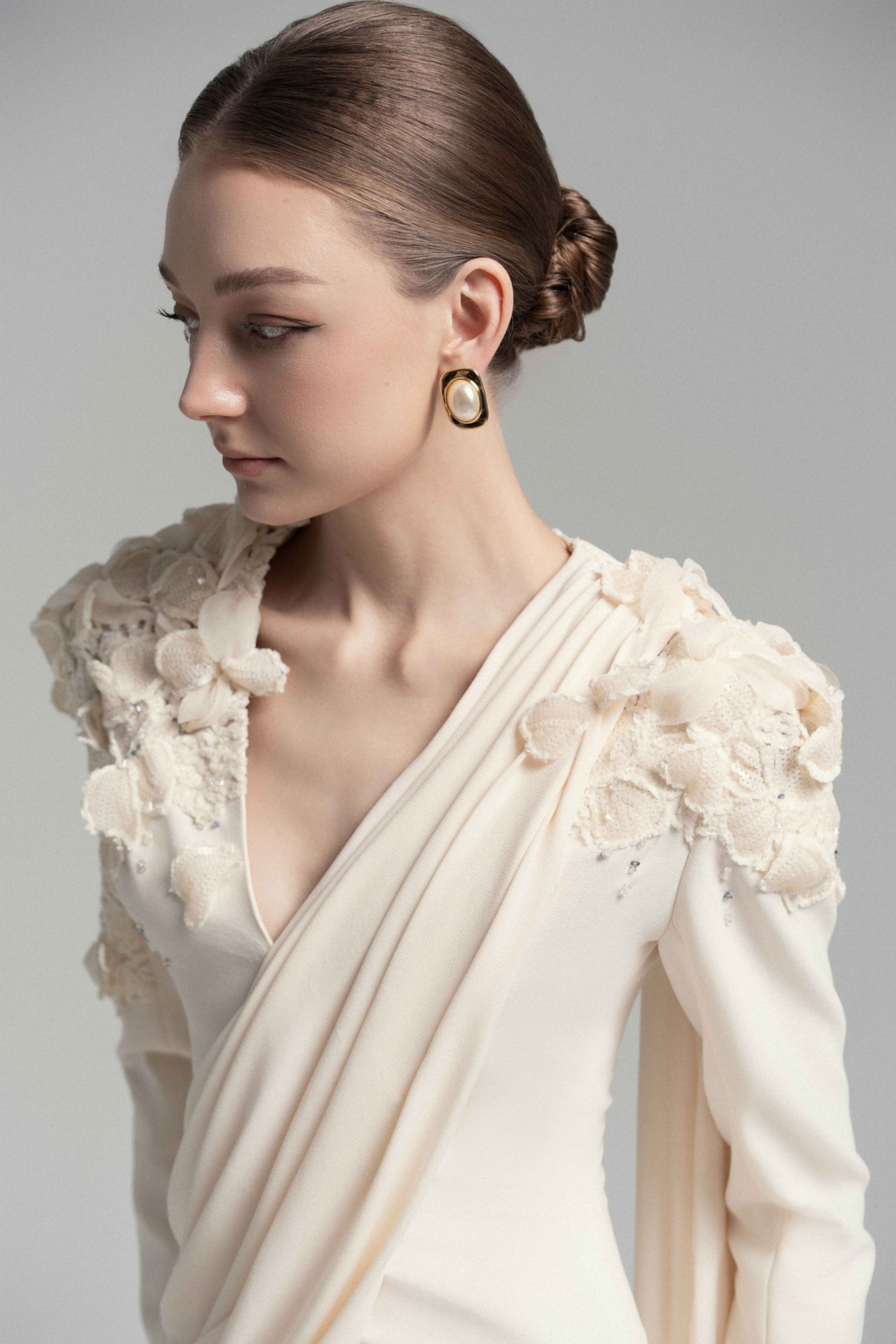 فستان طويل من الدانتيل المزين بزهور باللون الشمبانيا مع تفاصيل من الشريط