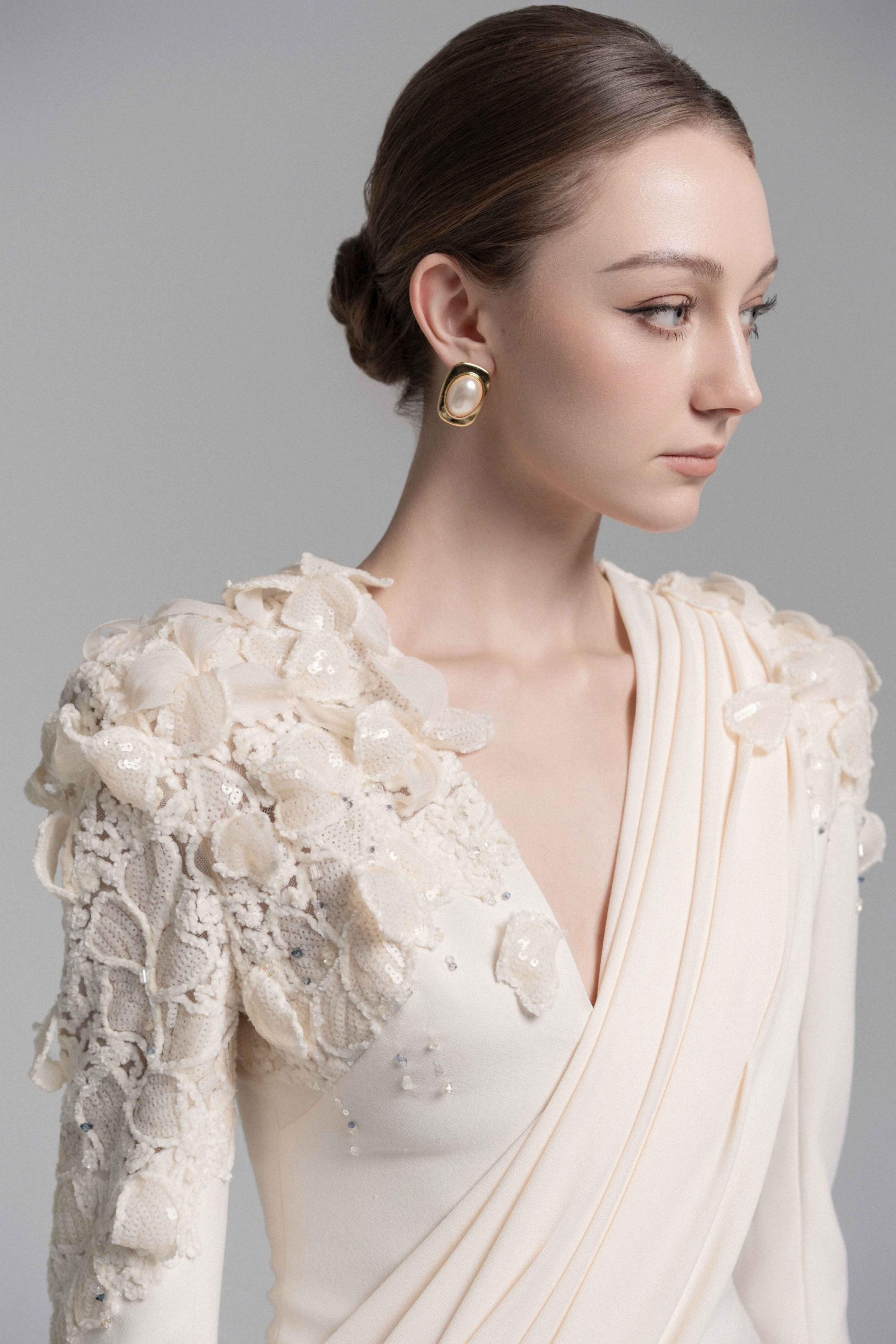 فستان طويل من الدانتيل المزين بزهور باللون الشمبانيا مع تفاصيل من الشريط