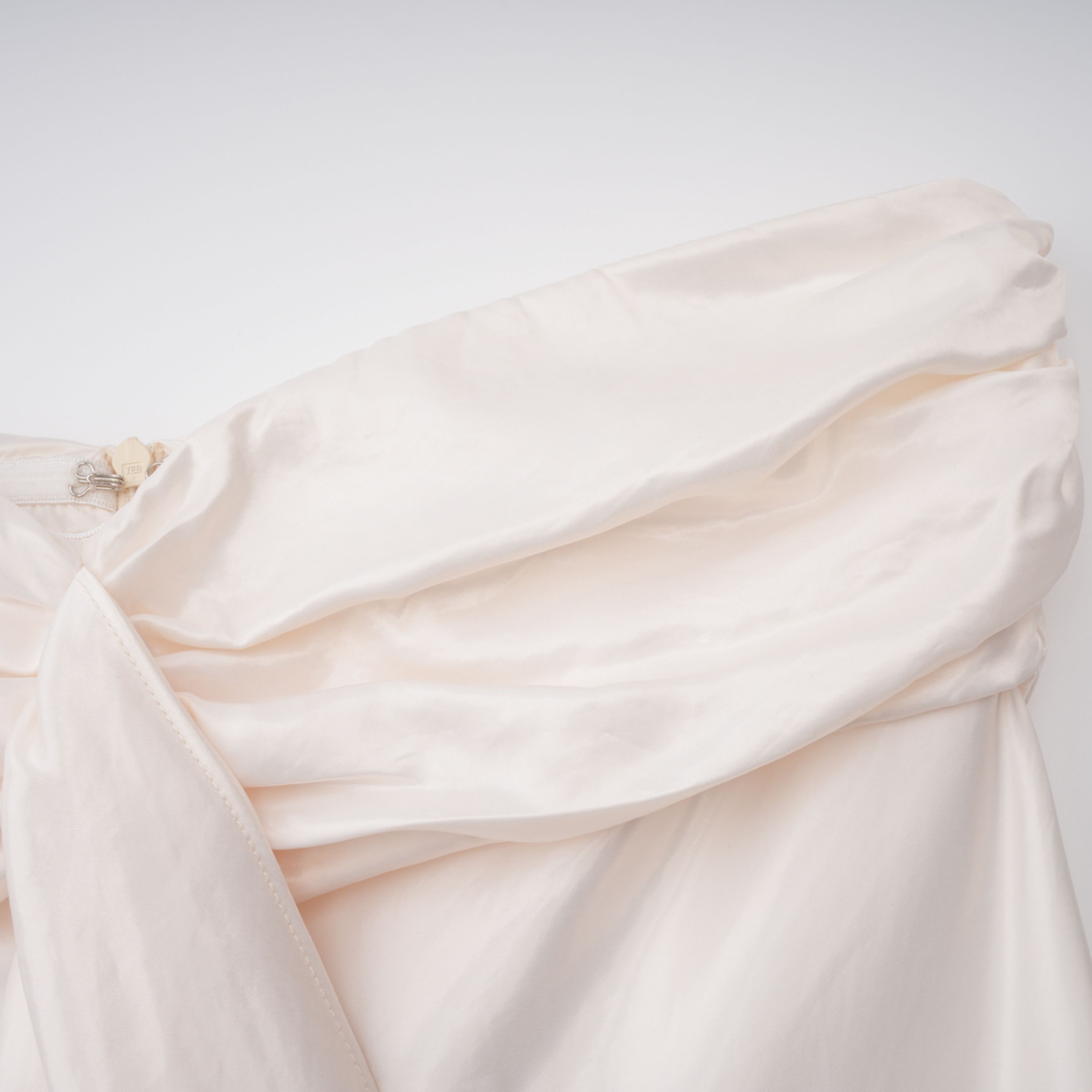 فستان طويل من الساتان باللون البيج الفاتح بدون أكمام ومزين بكشكشة