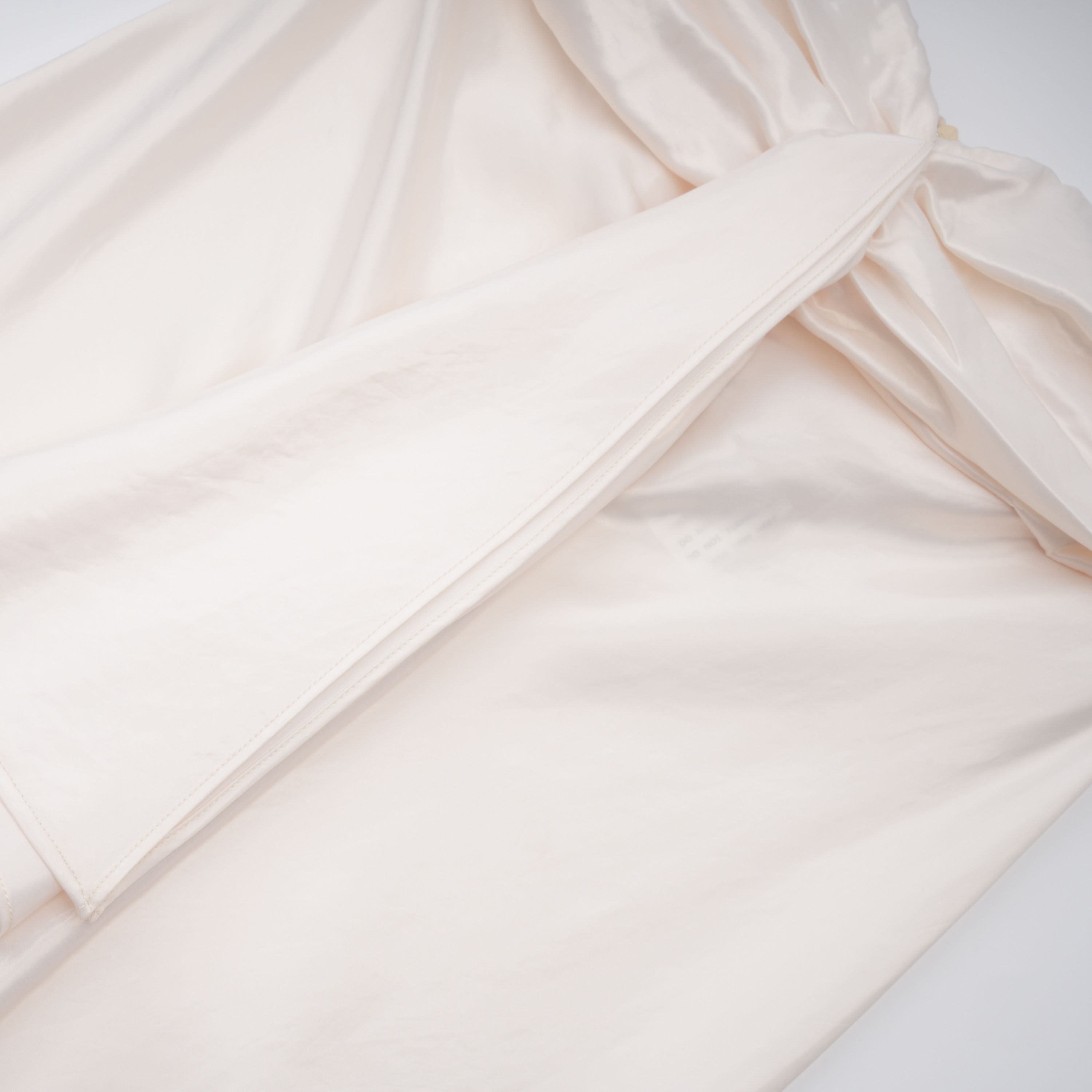 فستان طويل من الساتان باللون البيج الفاتح بدون أكمام ومزين بكشكشة